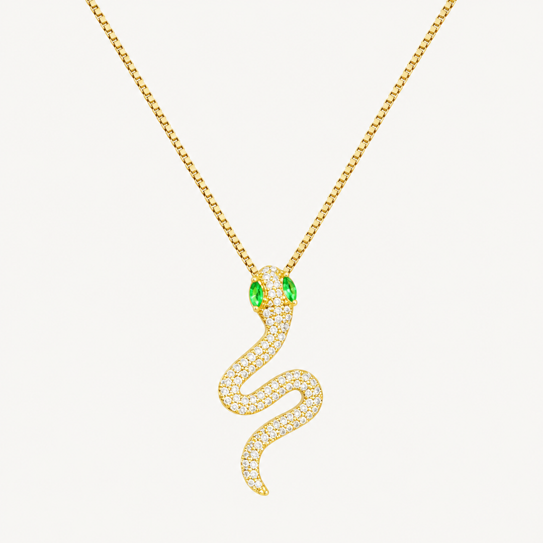Gold snake pendant necklace with green eyes