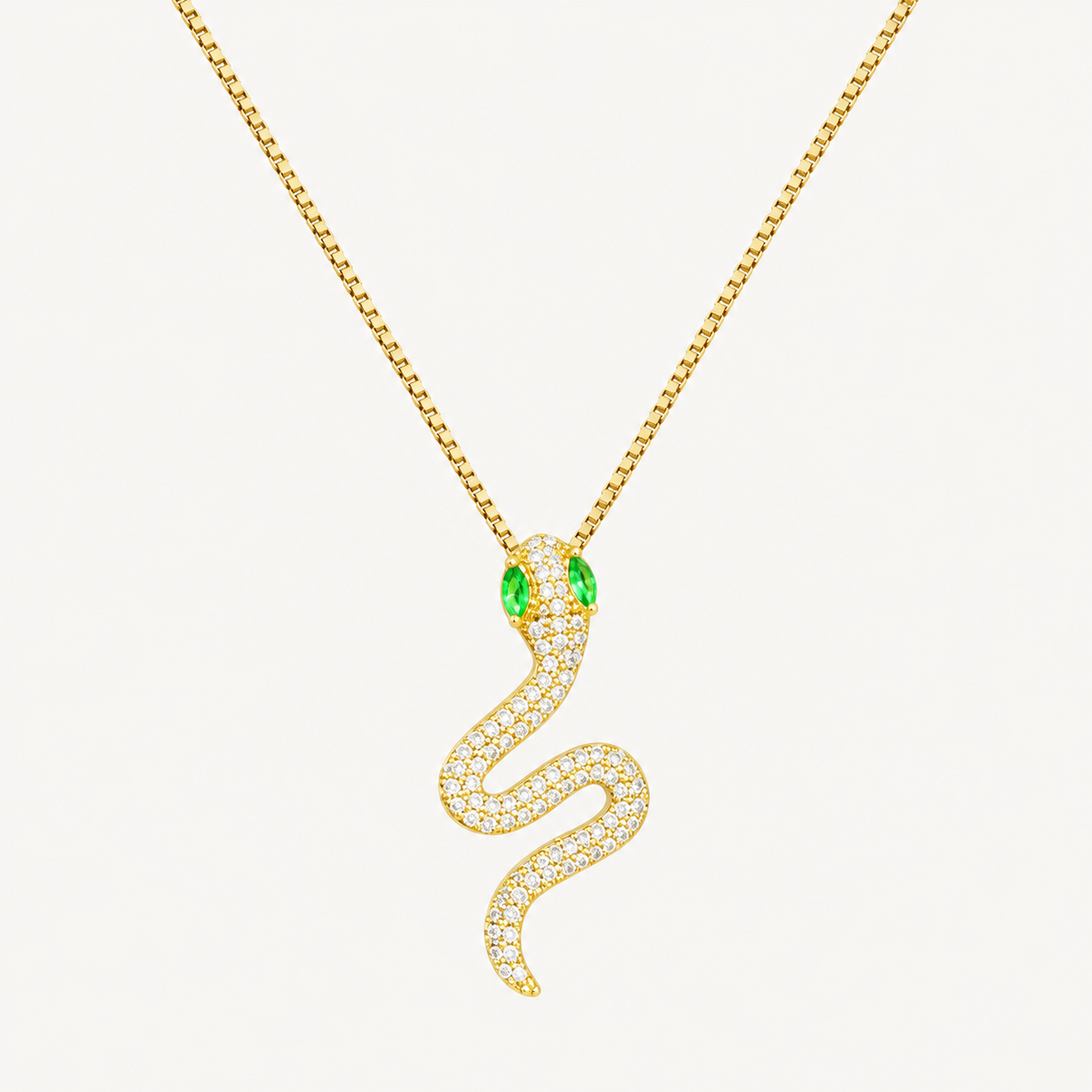 Gold snake pendant necklace with green eyes